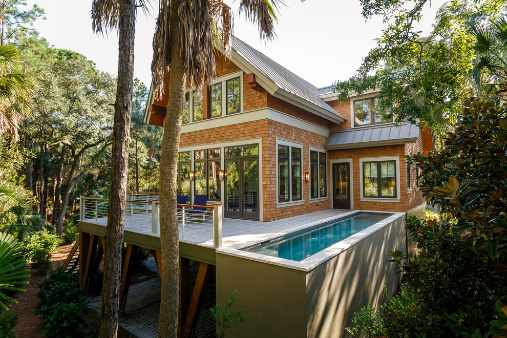 Diseño de fachada de casa marrón costera de dos plantas con revestimiento de vinilo, tejado a dos aguas y tejado de metal