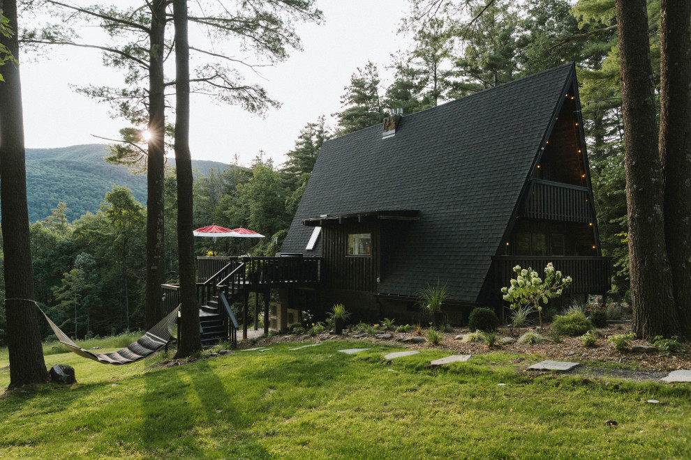 Ejemplo de fachada de casa negra vintage de tamaño medio de tres plantas con revestimiento de madera y tejado de teja de madera