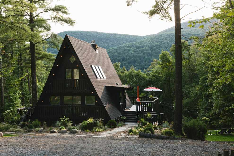Ejemplo de fachada de casa negra vintage de tamaño medio de tres plantas con revestimiento de madera y tejado de teja de madera