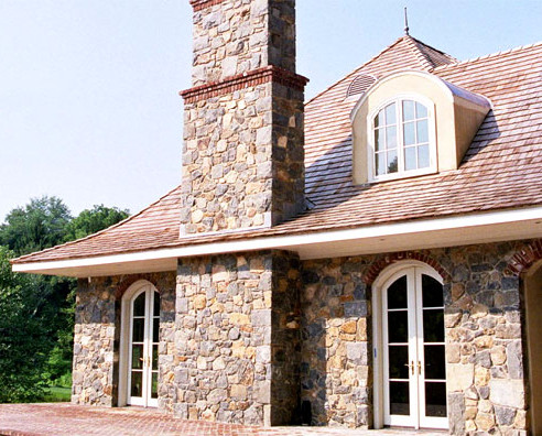 Ejemplo de fachada blanca clásica renovada de tamaño medio de dos plantas con revestimiento de piedra y tejado a cuatro aguas