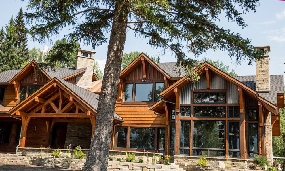 Diseño de fachada marrón de estilo americano grande de dos plantas con revestimientos combinados y tejado a dos aguas