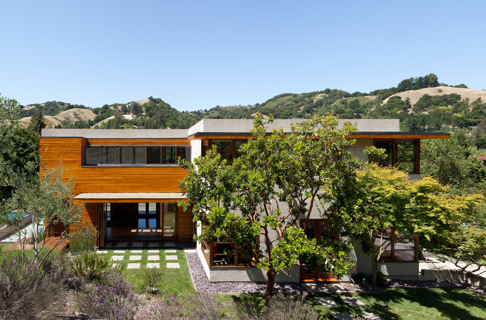 Cette image montre une grande façade de maison minimaliste à deux étages et plus avec un revêtement mixte et un toit plat.
