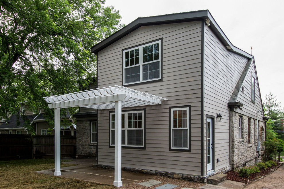 Ejemplo de fachada de casa gris campestre de tamaño medio de dos plantas con revestimiento de aglomerado de cemento, tejado a dos aguas y tejado de teja de madera