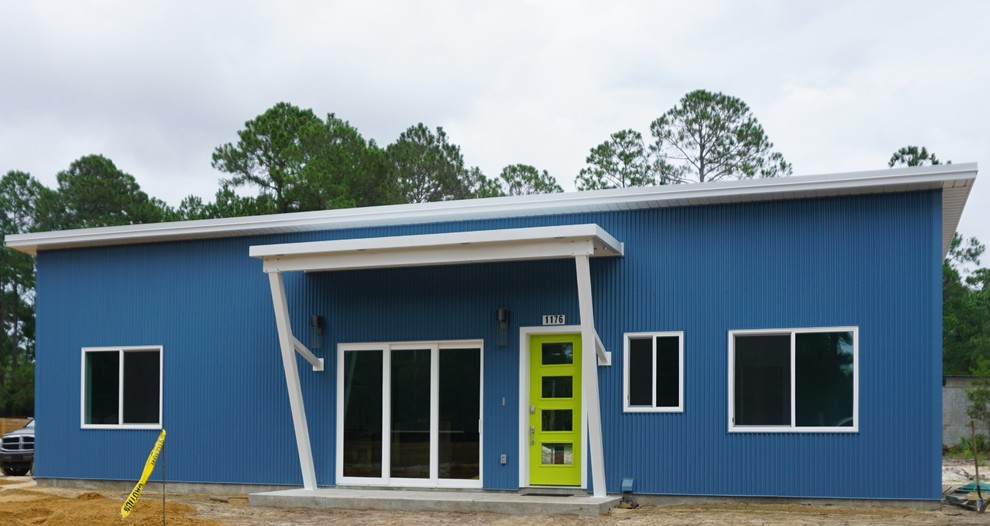 Immagine della villa piccola blu moderna a un piano con rivestimento in metallo, tetto piano e copertura in metallo o lamiera