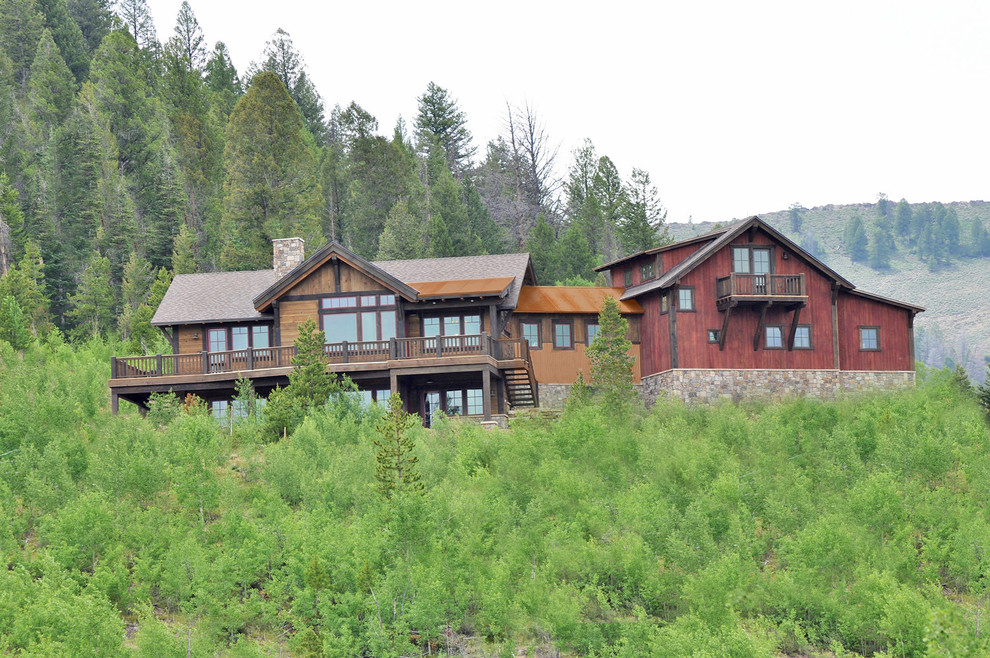 This is an example of a medium sized and brown rustic house exterior in Denver with three floors and wood cladding.