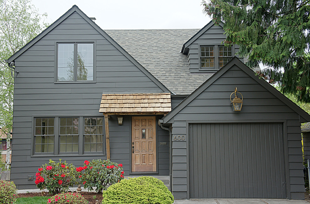 Photo of a medium sized and black traditional detached house in Portland with three floors, concrete fibreboard cladding, a pitched roof and a shingle roof.