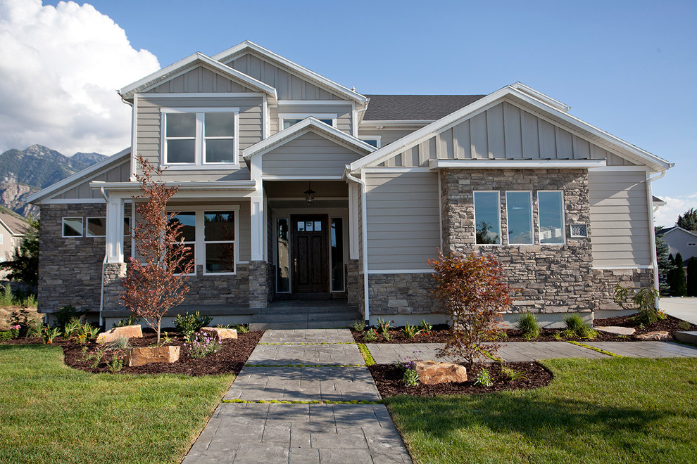 Ejemplo de fachada de casa gris de estilo americano de tamaño medio de dos plantas con revestimientos combinados, tejado a dos aguas y tejado de teja de madera