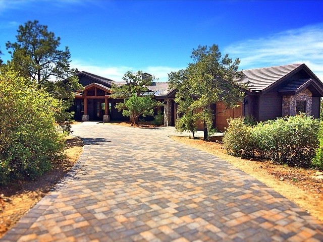 This is an example of a medium sized and brown rustic bungalow house exterior in Phoenix with stone cladding.
