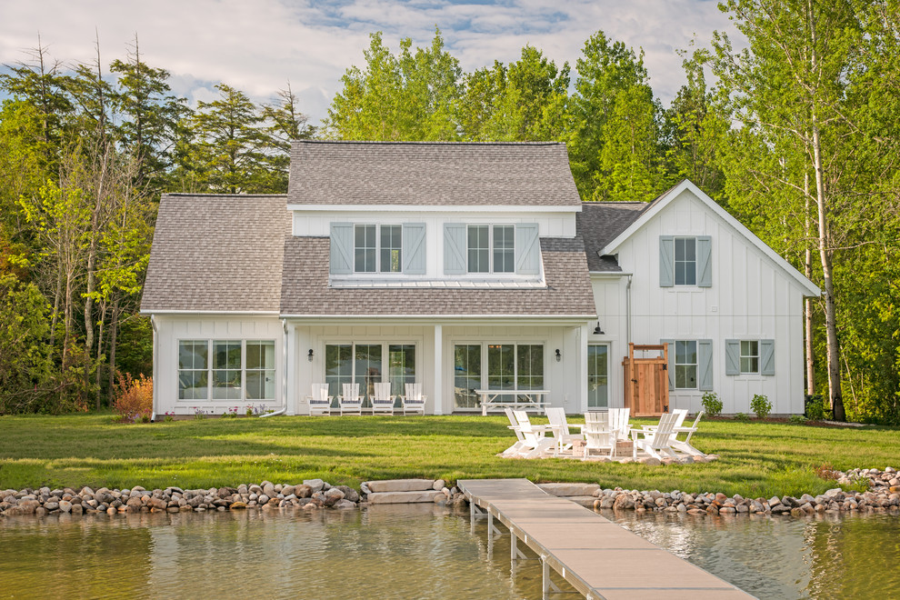 Modelo de fachada de casa blanca de estilo de casa de campo de dos plantas con revestimiento de vinilo, tejado a dos aguas y tejado de teja de madera
