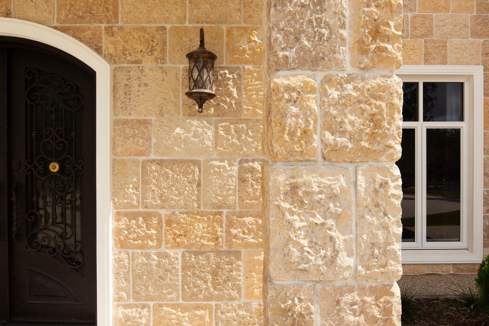 Ejemplo de fachada de casa beige clásica grande de dos plantas con revestimiento de piedra