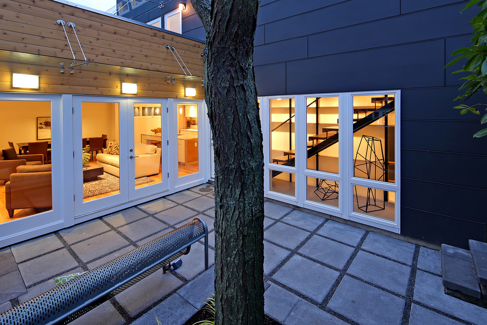 Modelo de fachada negra minimalista con revestimientos combinados, tejado a dos aguas y tejado de metal