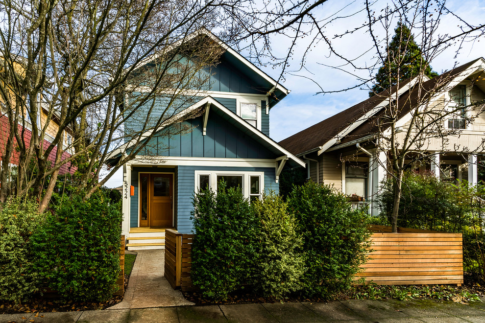 Photo of a medium sized and blue traditional two floor detached house in Seattle with concrete fibreboard cladding, a pitched roof and a shingle roof.