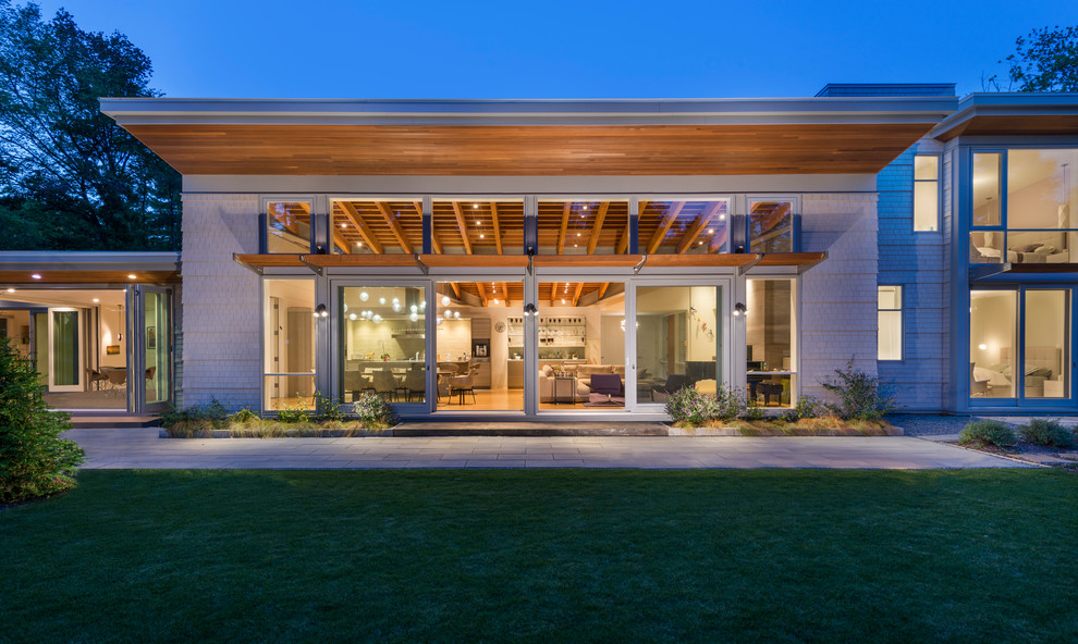 Идея дизайна: большой, деревянный, серый частный загородный дом в современном стиле с односкатной крышей
