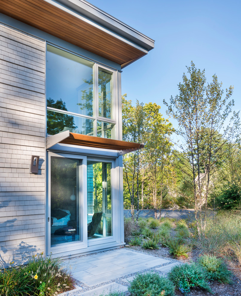 Пример оригинального дизайна: большой, двухэтажный, деревянный, серый частный загородный дом в современном стиле с крышей из смешанных материалов
