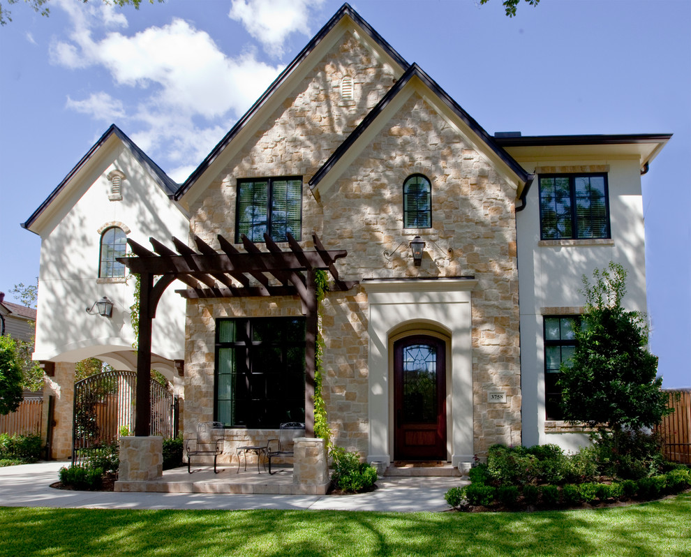 Ejemplo de fachada de casa beige clásica de tamaño medio de dos plantas con revestimientos combinados y tejado a dos aguas