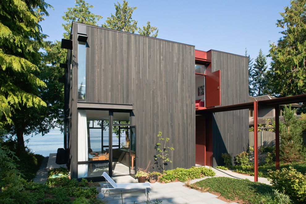 Exemple d'une façade de maison grise tendance en bois de taille moyenne et à un étage avec un toit plat.