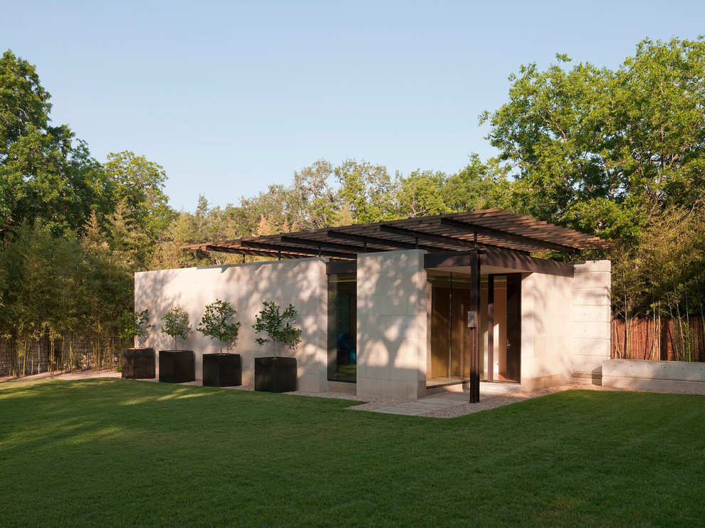 Cette photo montre une petite façade de maison beige moderne de plain-pied avec un toit plat et un revêtement mixte.