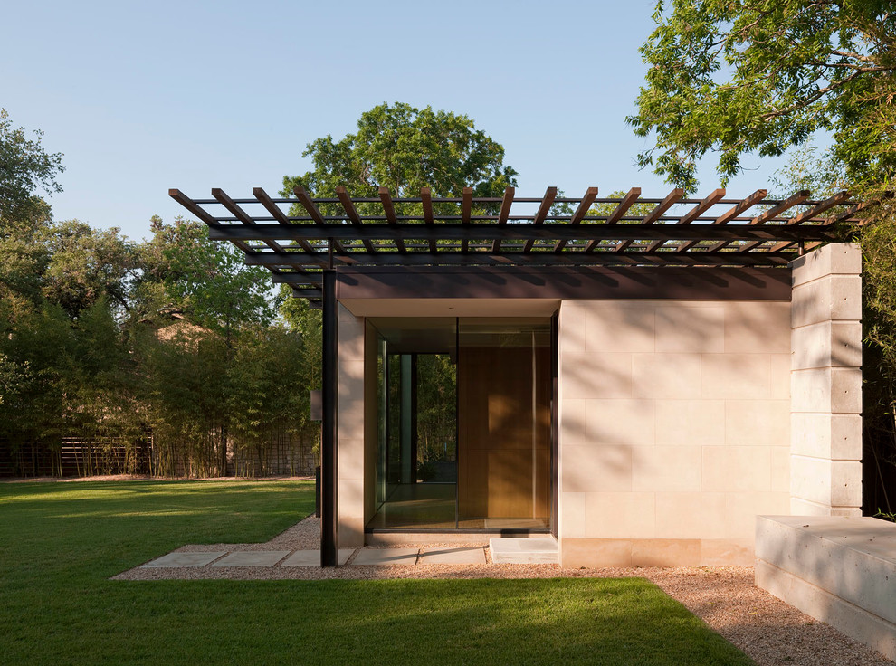 Kleines, Einstöckiges Modernes Einfamilienhaus mit beiger Fassadenfarbe und Flachdach in Austin