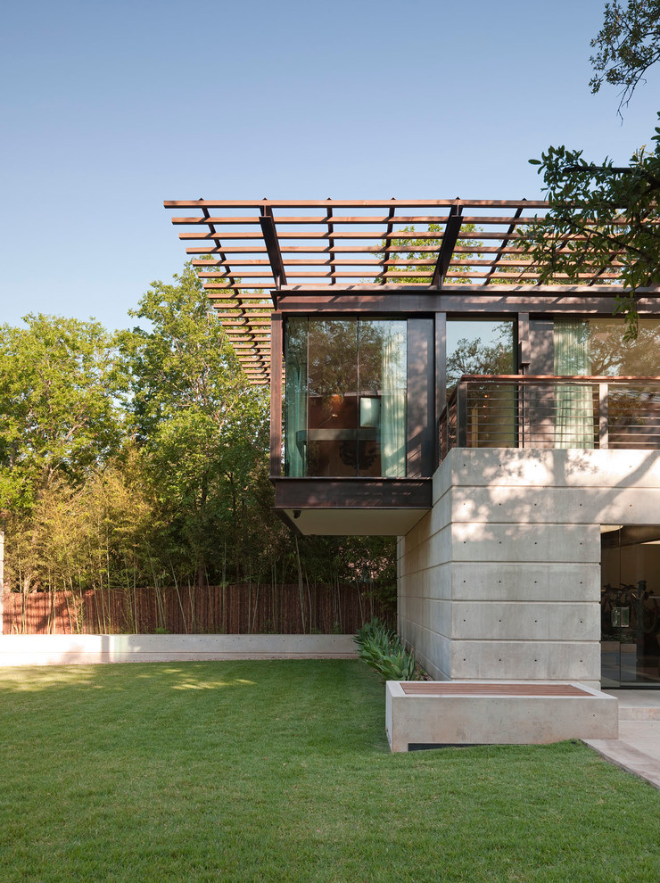 На фото: двухэтажный, серый частный загородный дом среднего размера в стиле модернизм с облицовкой из бетона и плоской крышей с