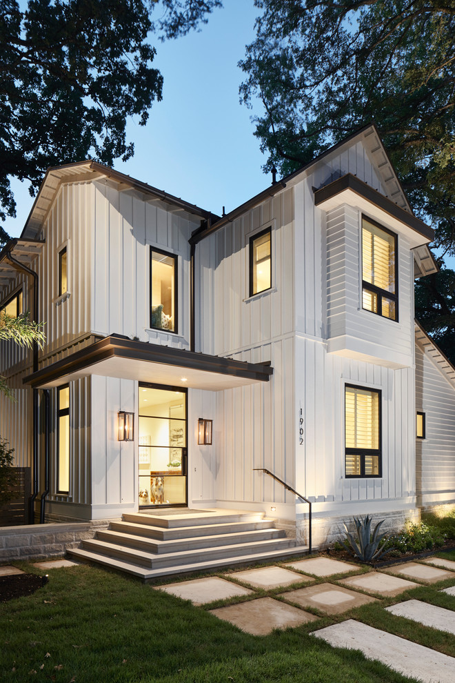 Modelo de fachada de casa blanca contemporánea de tamaño medio de dos plantas con revestimiento de madera, tejado a dos aguas y tejado de metal