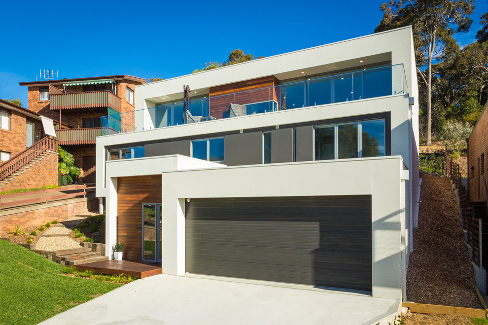 This is an example of a medium sized and white modern house exterior in Other with three floors, mixed cladding and a flat roof.