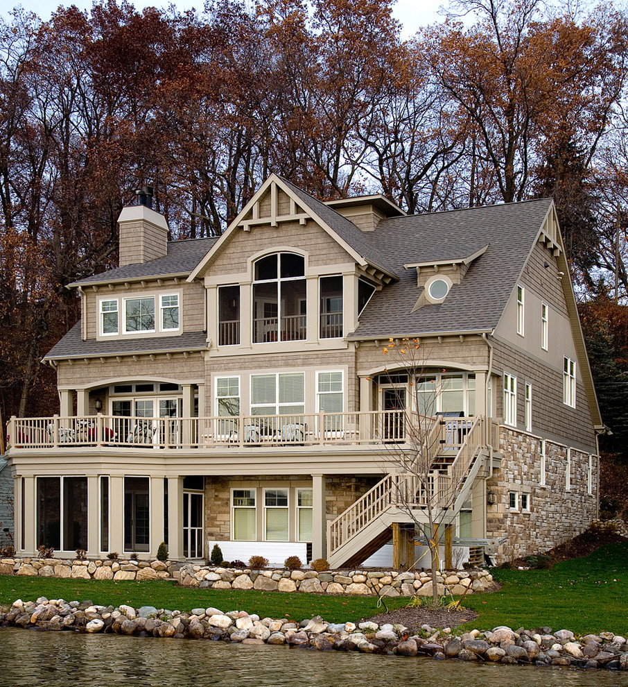 Ejemplo de fachada de casa beige de estilo americano extra grande de tres plantas con tejado a dos aguas, revestimiento de madera y tejado de teja de madera