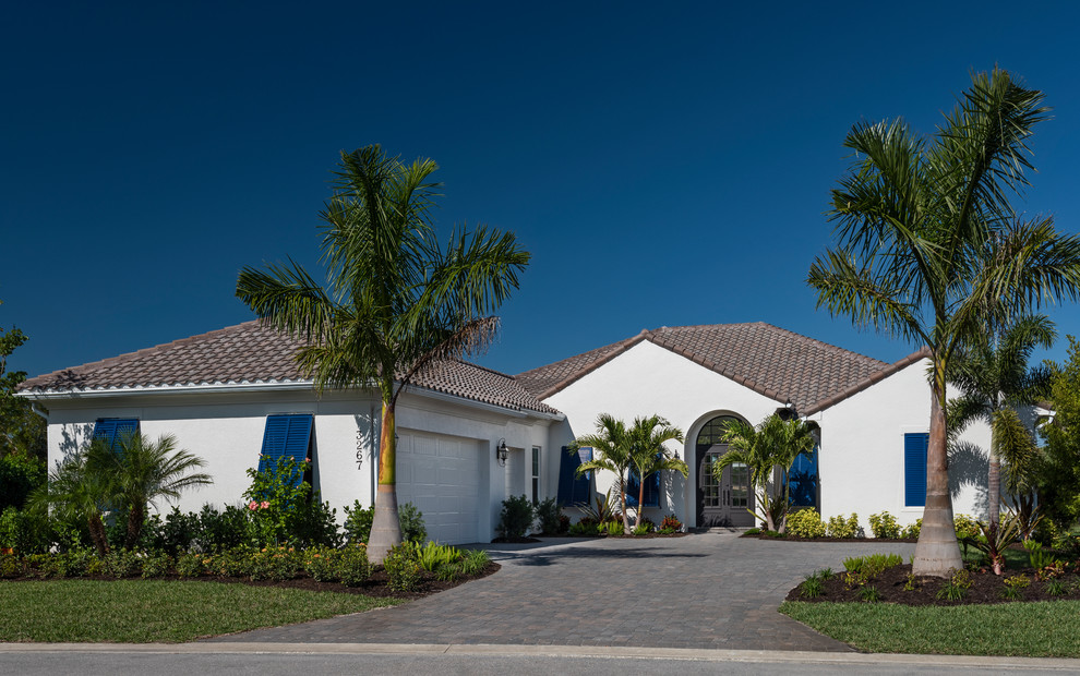 Imagen de fachada de casa blanca costera de tamaño medio de una planta con revestimiento de estuco y tejado de teja de barro