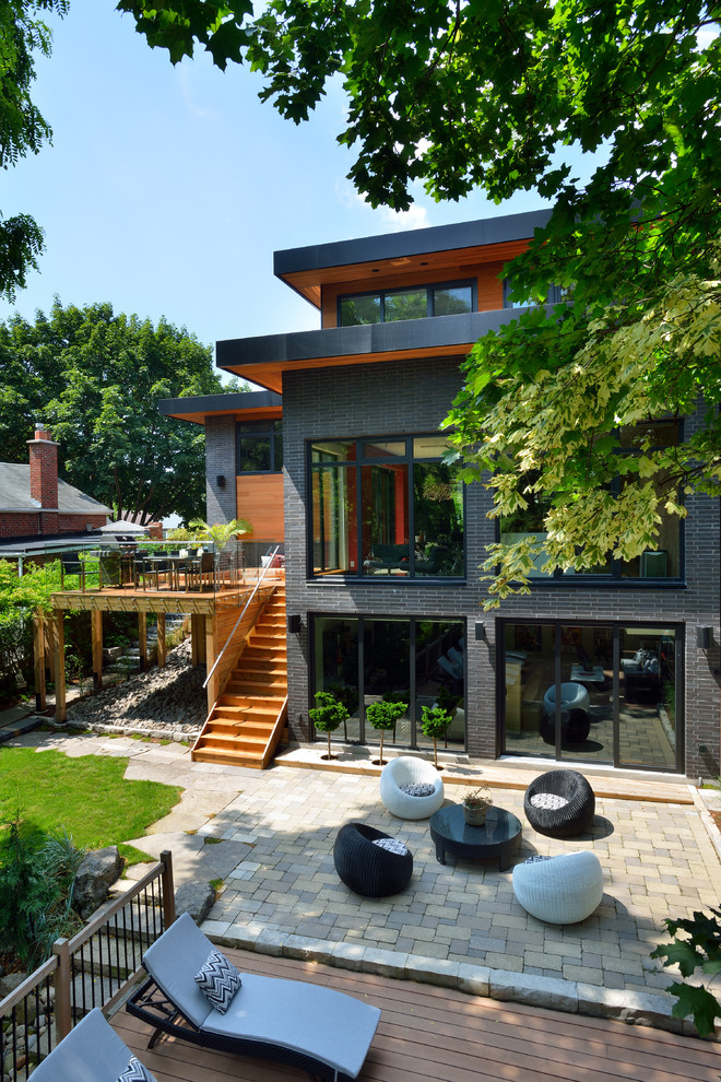 Contemporary gray three-story brick exterior home idea in Toronto