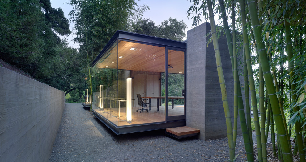 Diseño de fachada moderna pequeña de una planta con revestimiento de hormigón y tejado plano