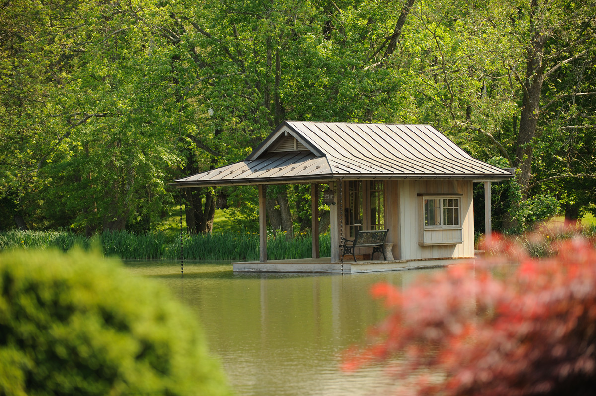 Cette photo montre une petite façade de maison beige asiatique en bois de plain-pied avec un toit en appentis et un toit en métal.