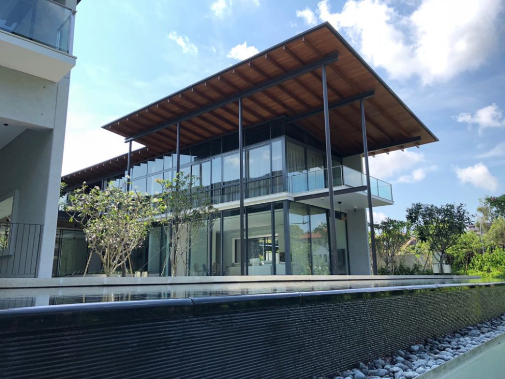 Cette photo montre une façade de maison moderne en bois avec un toit plat et un toit mixte.