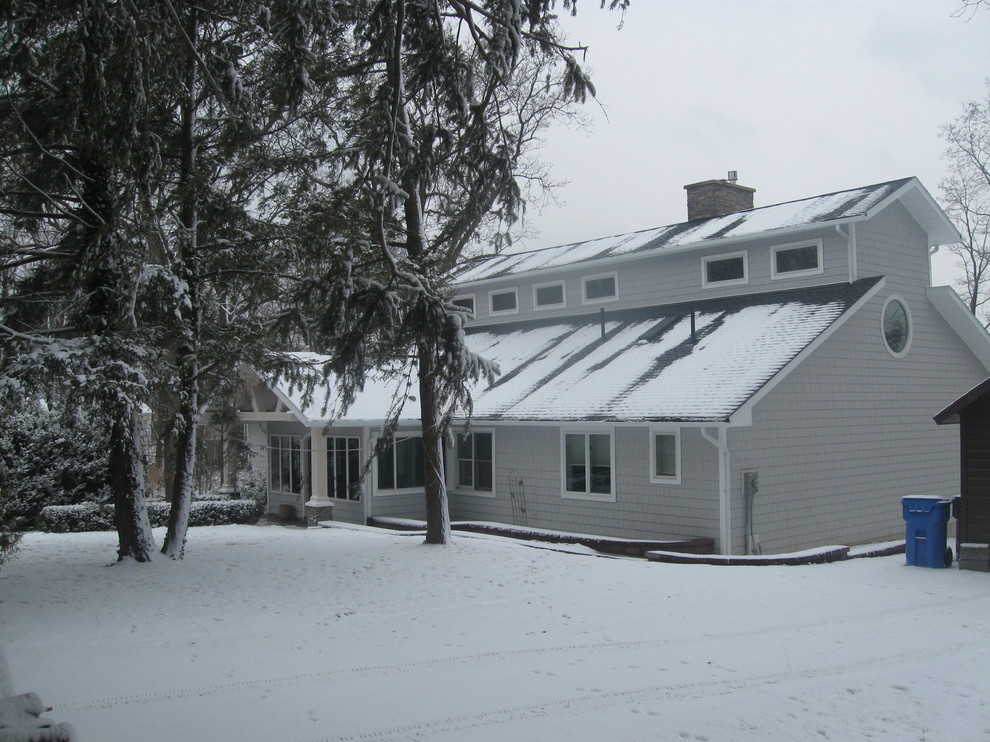 На фото: одноэтажный, серый дом среднего размера в современном стиле с облицовкой из ЦСП и двускатной крышей с