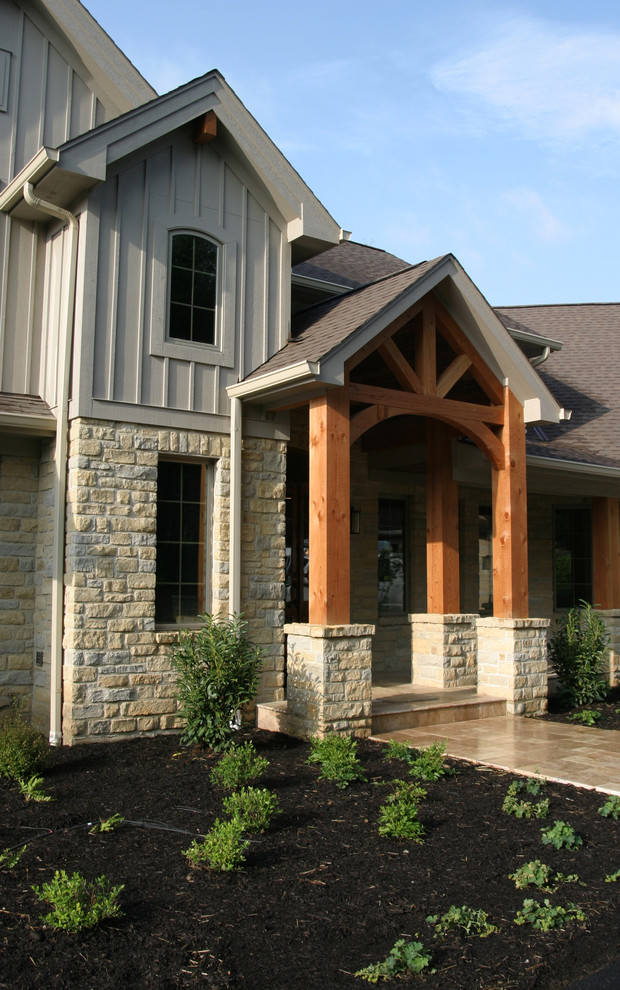 Cette image montre une grande façade de maison beige craftsman en pierre à un étage avec un toit à deux pans.