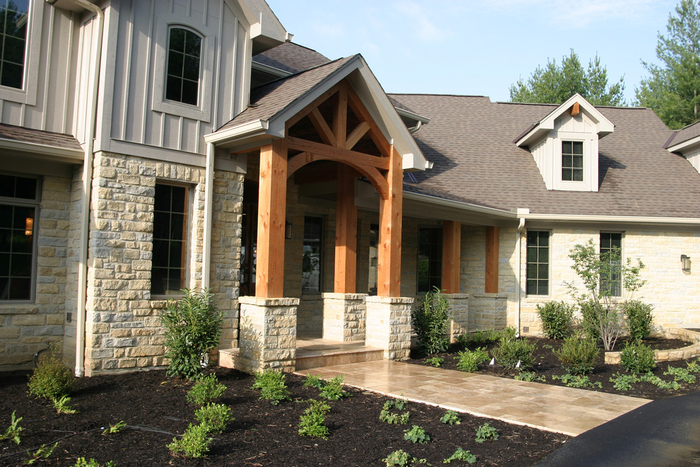 Idée de décoration pour une grande façade de maison beige craftsman en pierre à un étage avec un toit à deux pans.