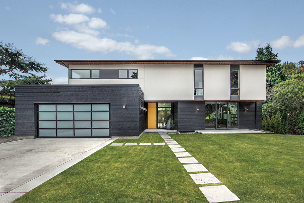 Réalisation d'une façade de maison design à un étage avec un revêtement mixte et un toit en appentis.