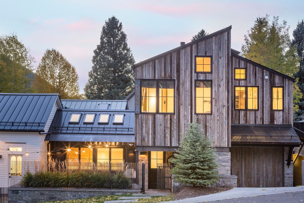 Идея дизайна: двухэтажный, деревянный, коричневый частный загородный дом в стиле рустика с односкатной крышей и металлической крышей