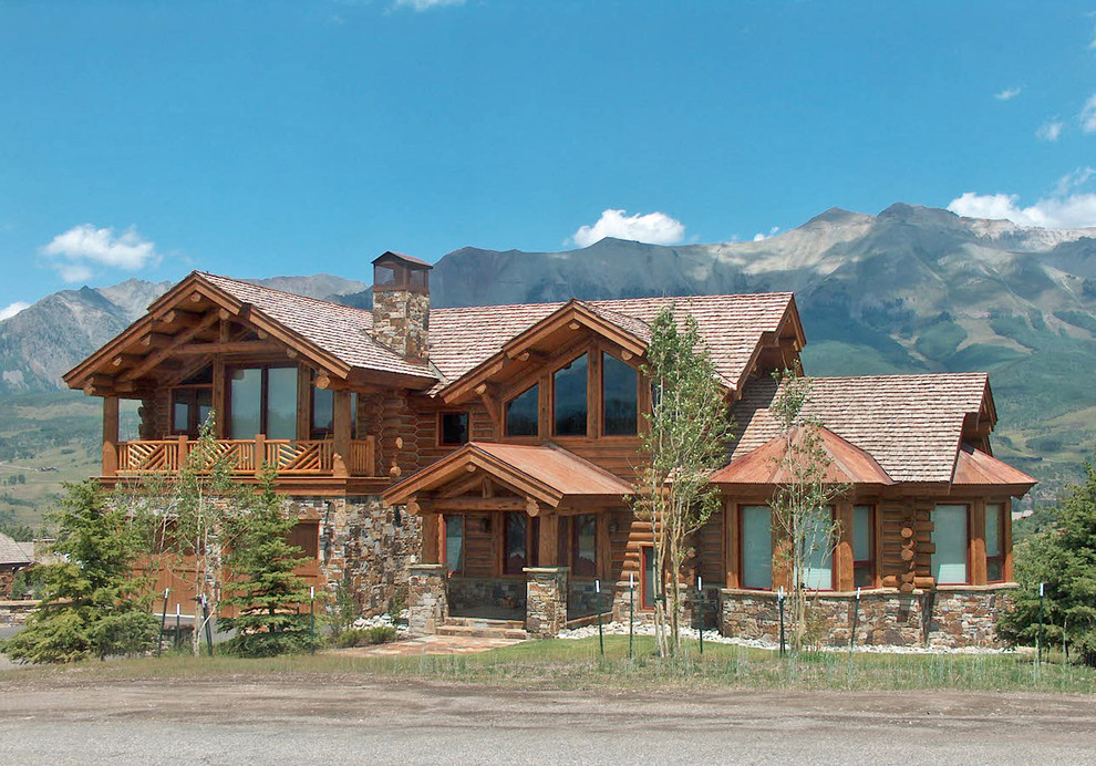 Exemple d'une grande façade de maison marron montagne en bois à un étage avec un toit à deux pans et un toit en shingle.