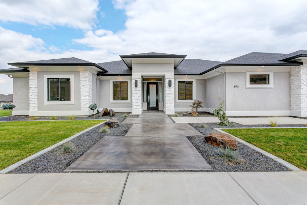 Mid-sized transitional gray one-story stucco house exterior photo in Seattle with a hip roof and a shingle roof