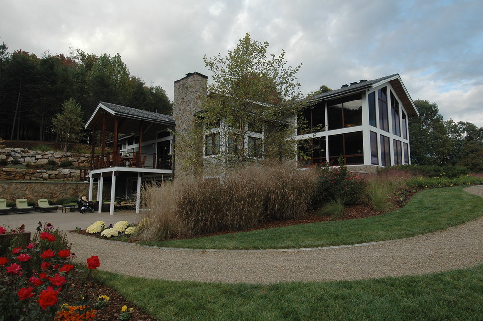 Imagen de fachada gris actual grande de dos plantas con revestimientos combinados y tejado a dos aguas