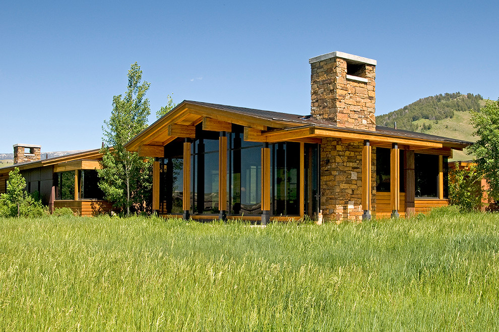 Inspiration pour une grande façade de maison marron minimaliste en bois avec un toit à deux pans.