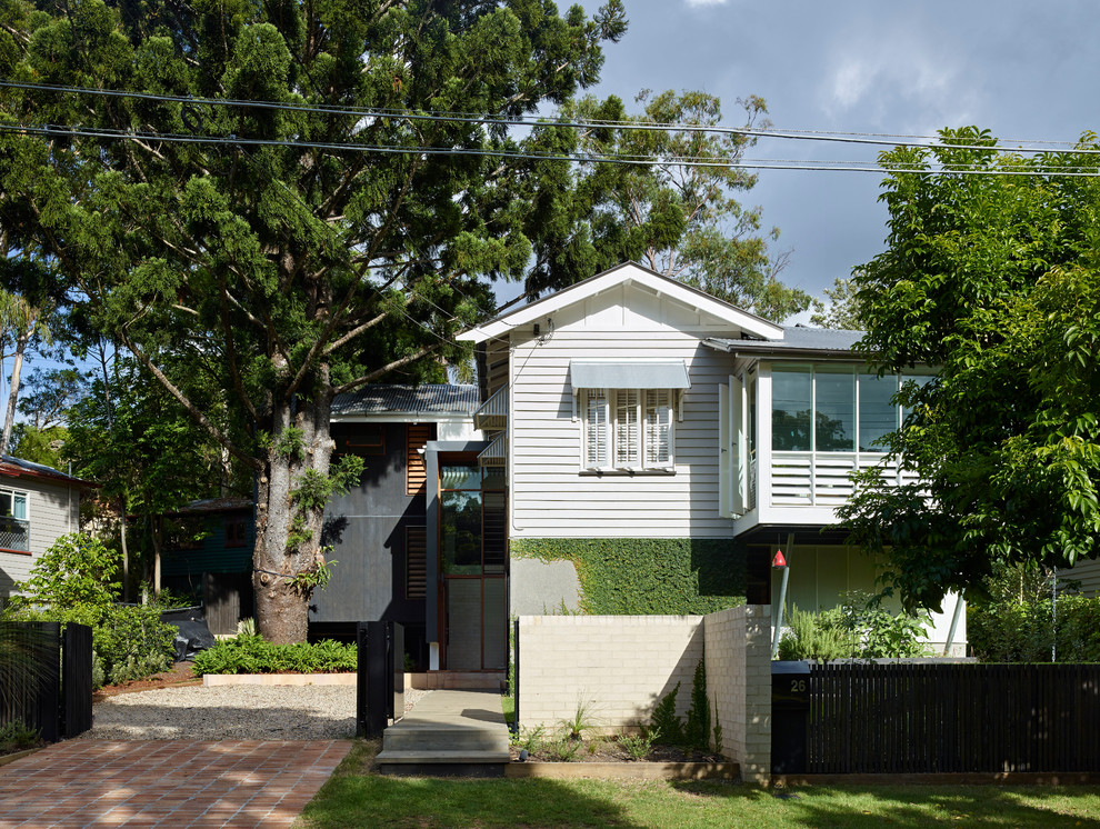 Exemple d'une façade de maison grise chic en bois de taille moyenne et à niveaux décalés.