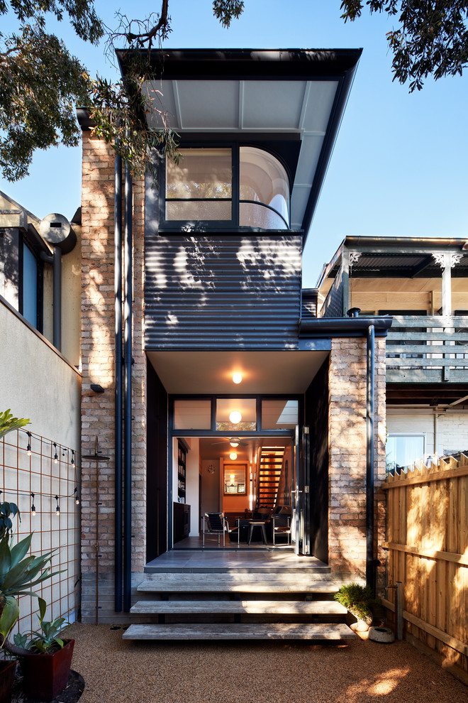 Kleines, Zweistöckiges Modernes Einfamilienhaus mit Backsteinfassade, roter Fassadenfarbe und Flachdach in Sydney