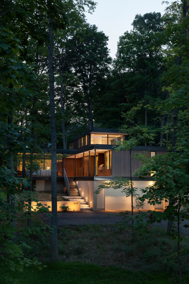 Diseño de fachada de casa marrón moderna pequeña de dos plantas con revestimiento de madera y tejado plano