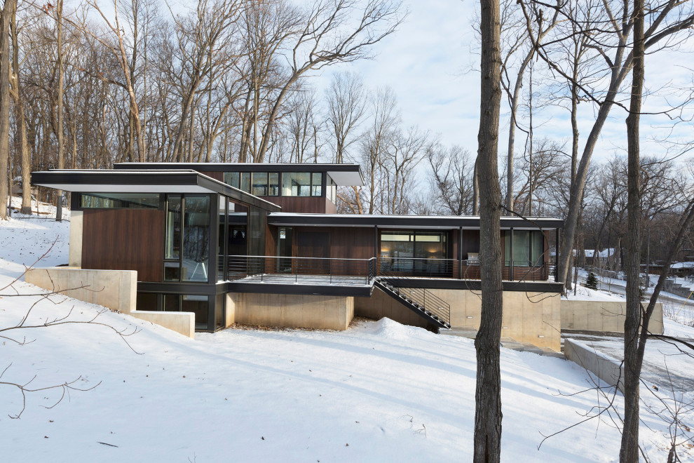 Kleines, Zweistöckiges Modernes Haus mit brauner Fassadenfarbe und Flachdach in Milwaukee