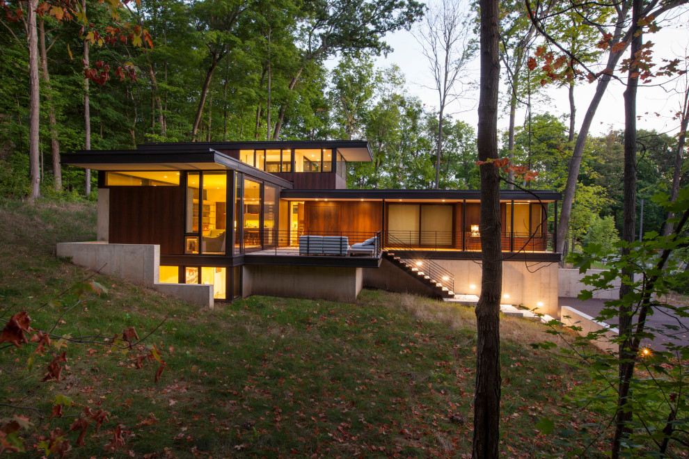Imagen de fachada de casa marrón moderna pequeña de dos plantas con revestimiento de madera y tejado plano