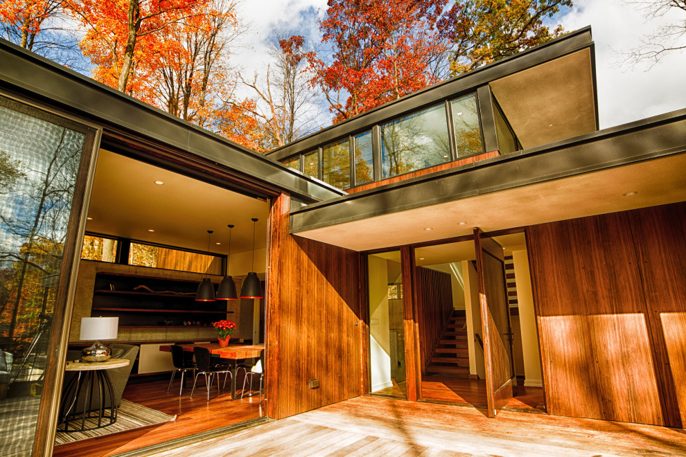 Стильный дизайн: маленький, двухэтажный, деревянный, коричневый частный загородный дом в стиле модернизм с плоской крышей для на участке и в саду - последний тренд