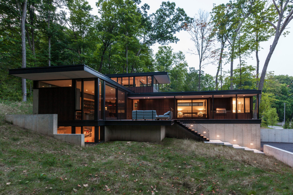 Aménagement d'une petite façade de maison marron moderne en bois à un étage avec un toit plat.
