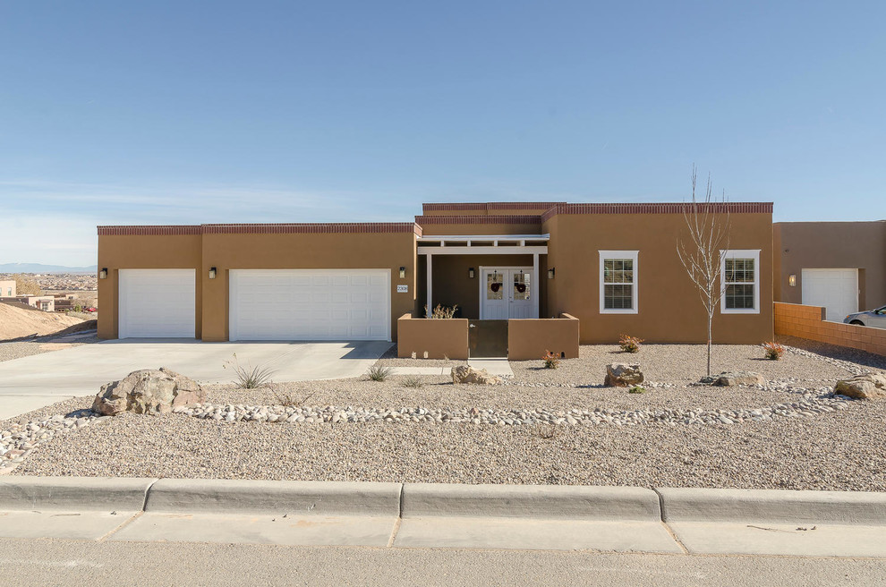 This is an example of a medium sized and brown bungalow render house exterior in Albuquerque with a flat roof.