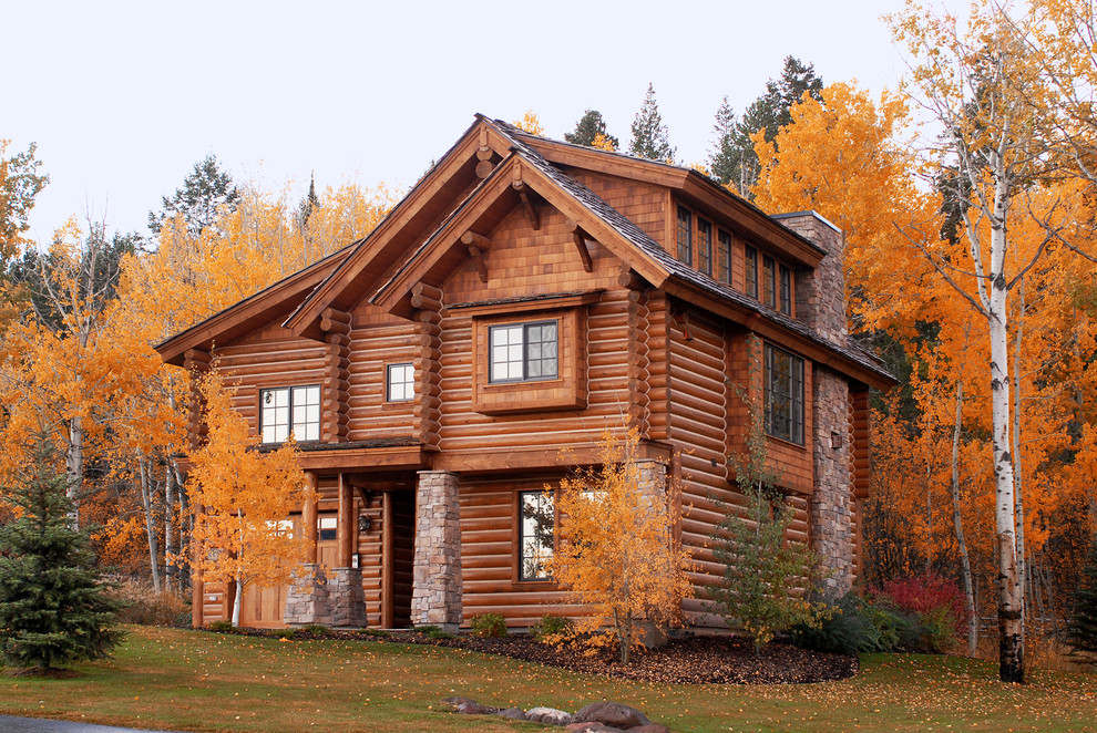 Стильный дизайн: двухэтажный, деревянный, коричневый дом среднего размера, из бревен в стиле рустика с двускатной крышей и крышей из гибкой черепицы - последний тренд