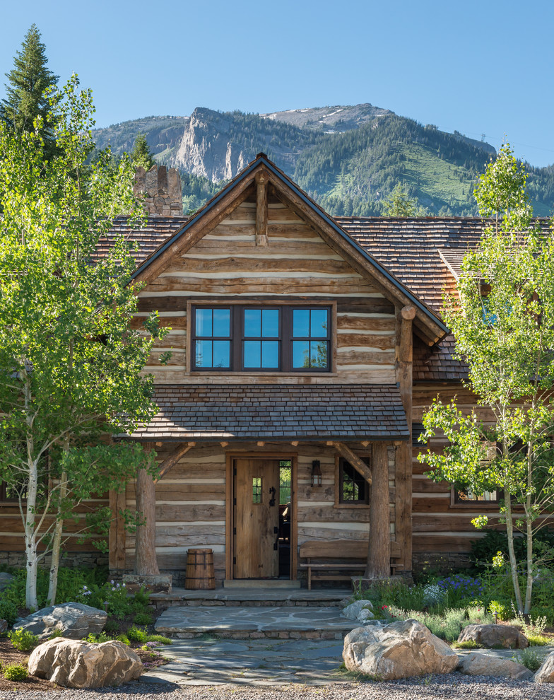 Inspiration for a large rustic two-story wood exterior home remodel in Other with a shingle roof